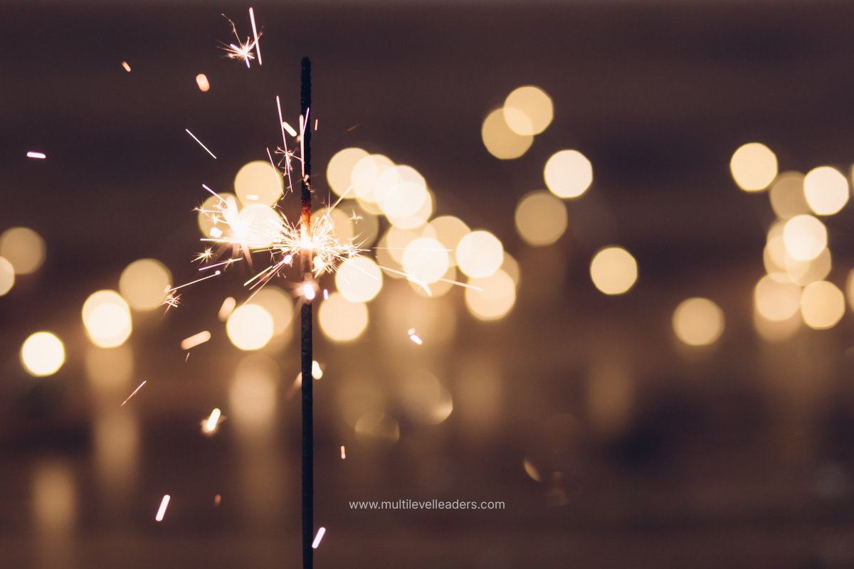 A sparkler glowing against warm New Year bokeh lights, symbolizing fresh starts and lasting change