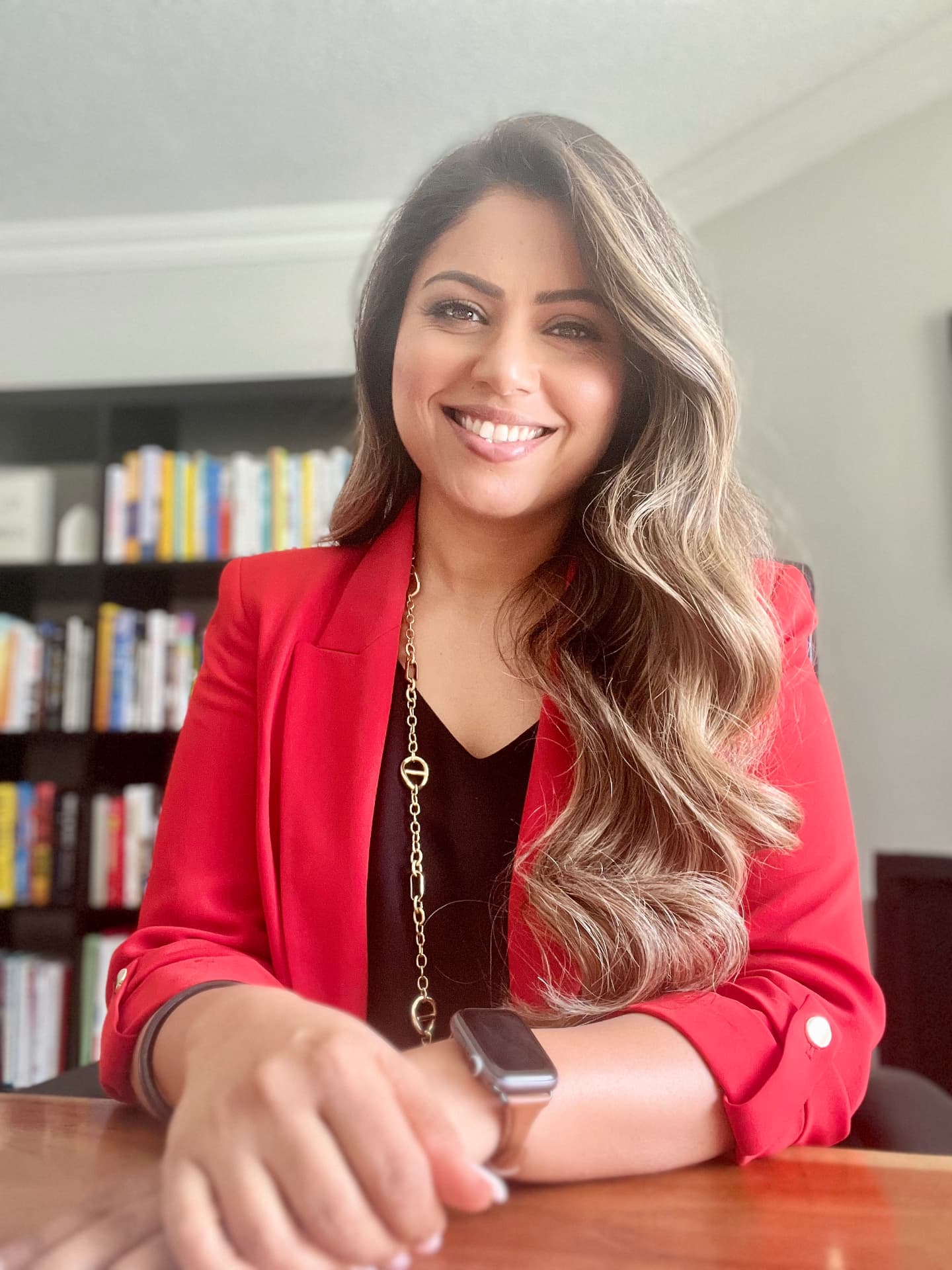 Sandeep Aujla smiling at her desk