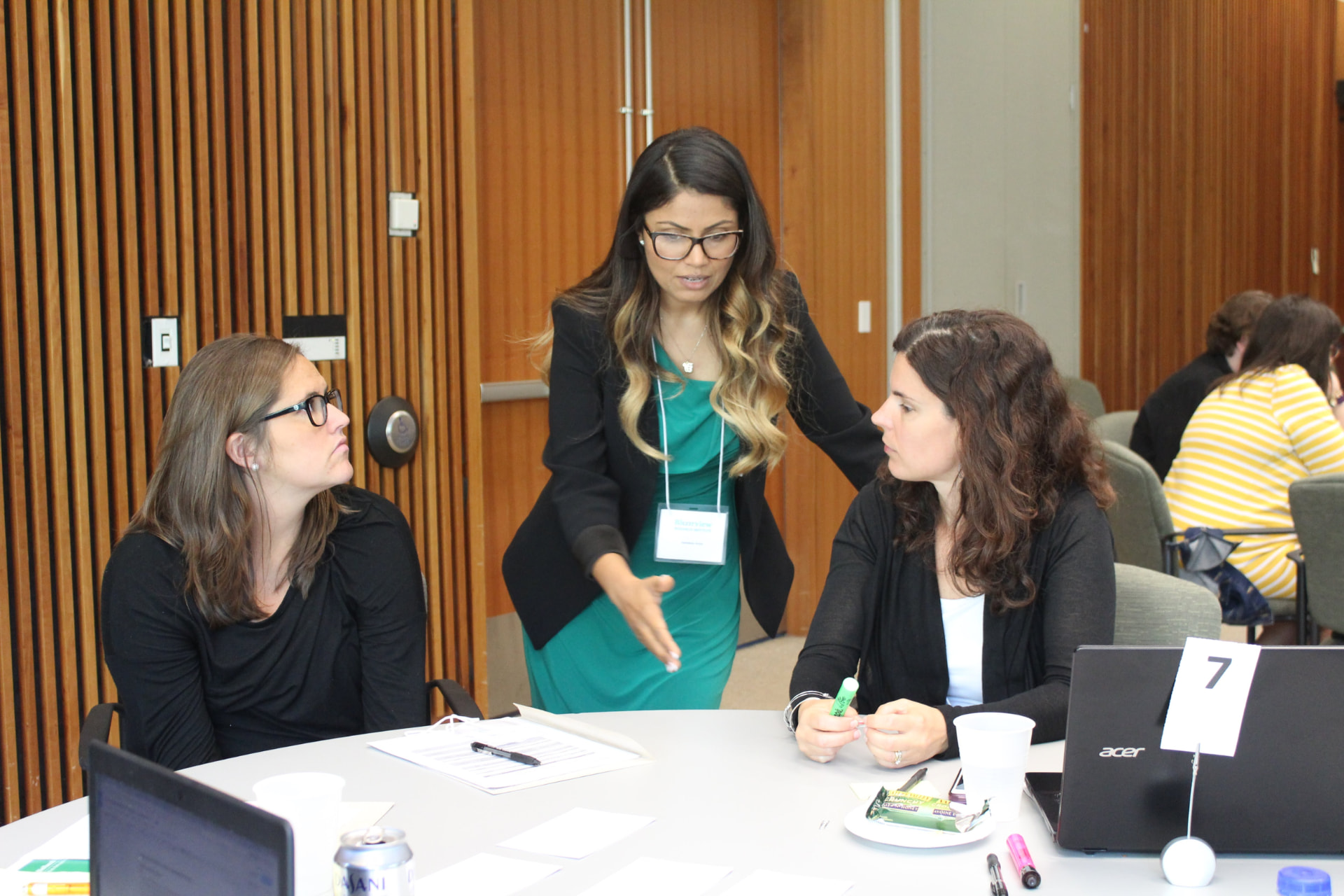 Sandeep Aujla coaching two leaders at a table during a facilitated breakout working session
