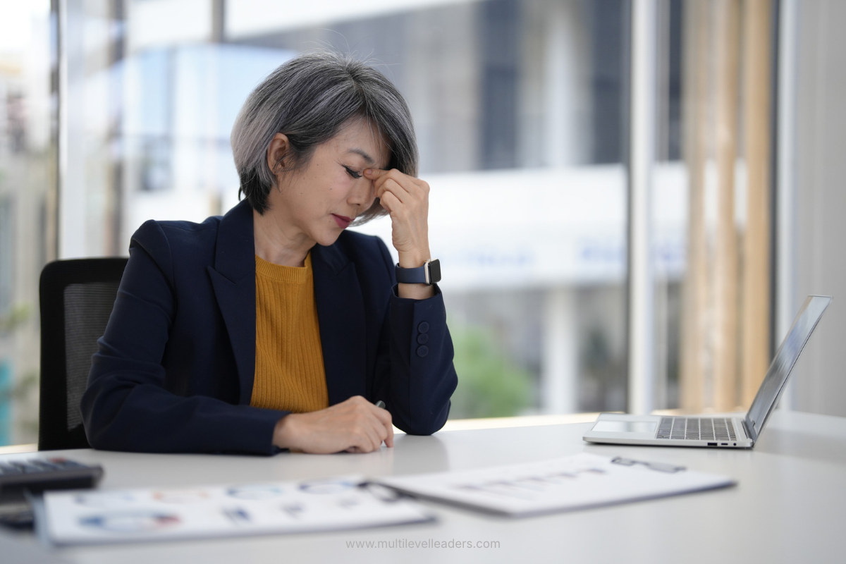 A senior leader sitting at a desk holding a composed expression while under high internal activation, illustrating why composure may differ from emotional regulation